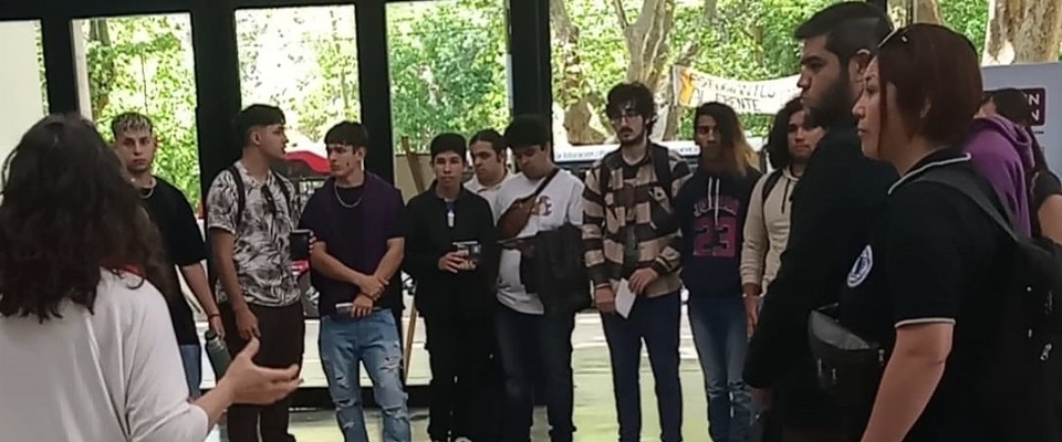 Estudiantes de escuelas secundarias reciben la bienvenida en el hall de la Facultad de Informática.