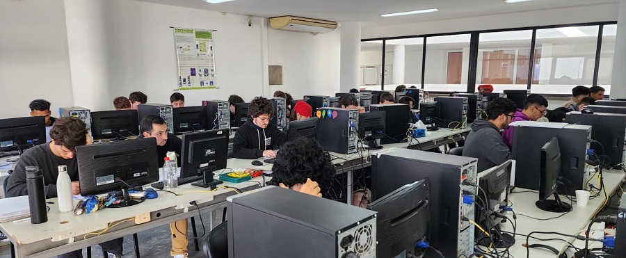 En un aula de la Facultad de Informática se lleva a cabo la decimocuarta edición del Torneo Argentino de Programación. Los participantes trabajan sobre las computadoras.